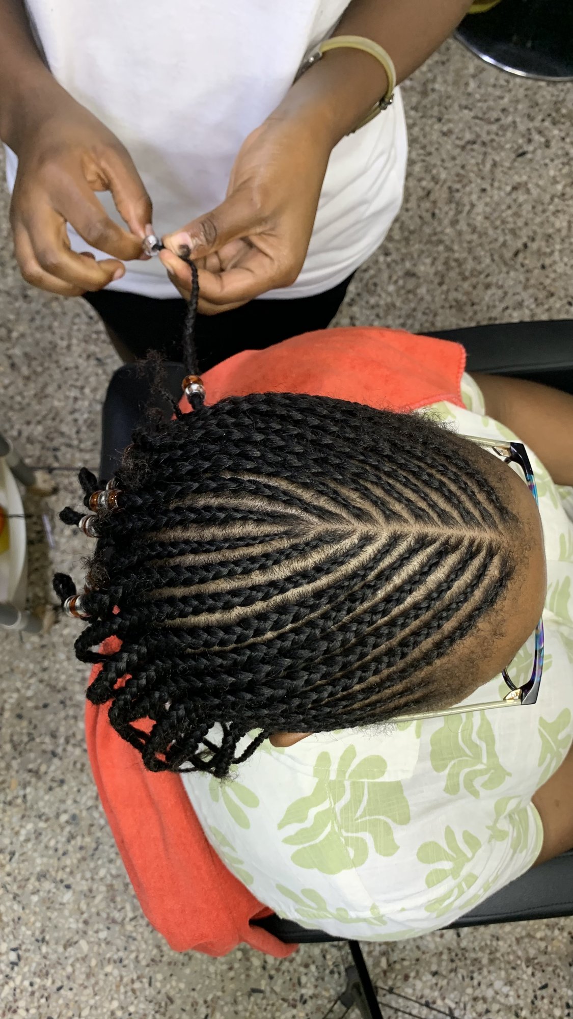 Cornrows being braided for a young client
