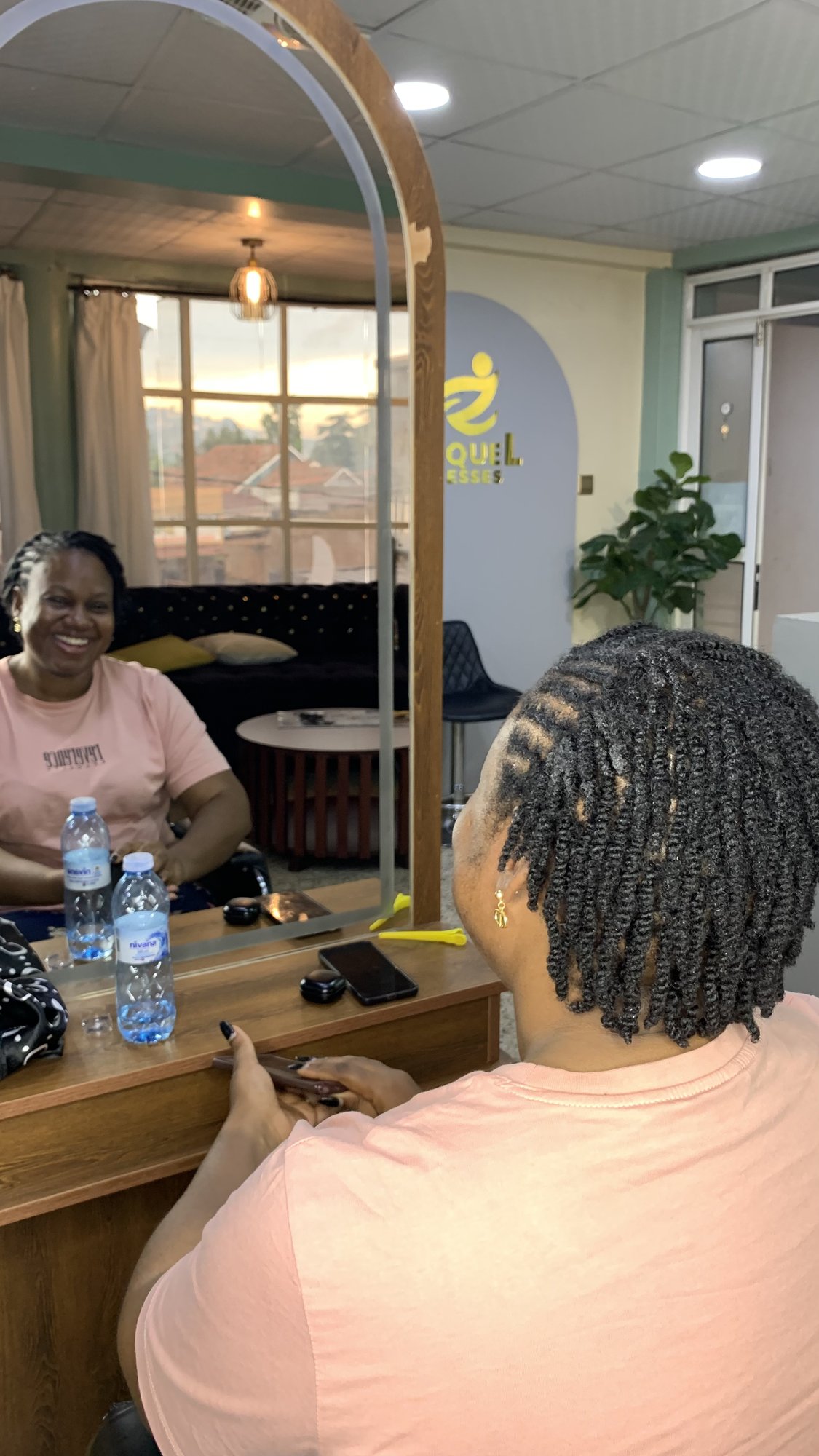 A client and stylist sharing a laugh in the mirror